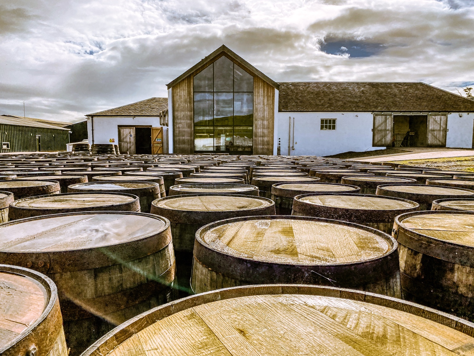 Lochlea Farm Distillery in Ayrshire mit Whiskyfässern vor der Brennerei
